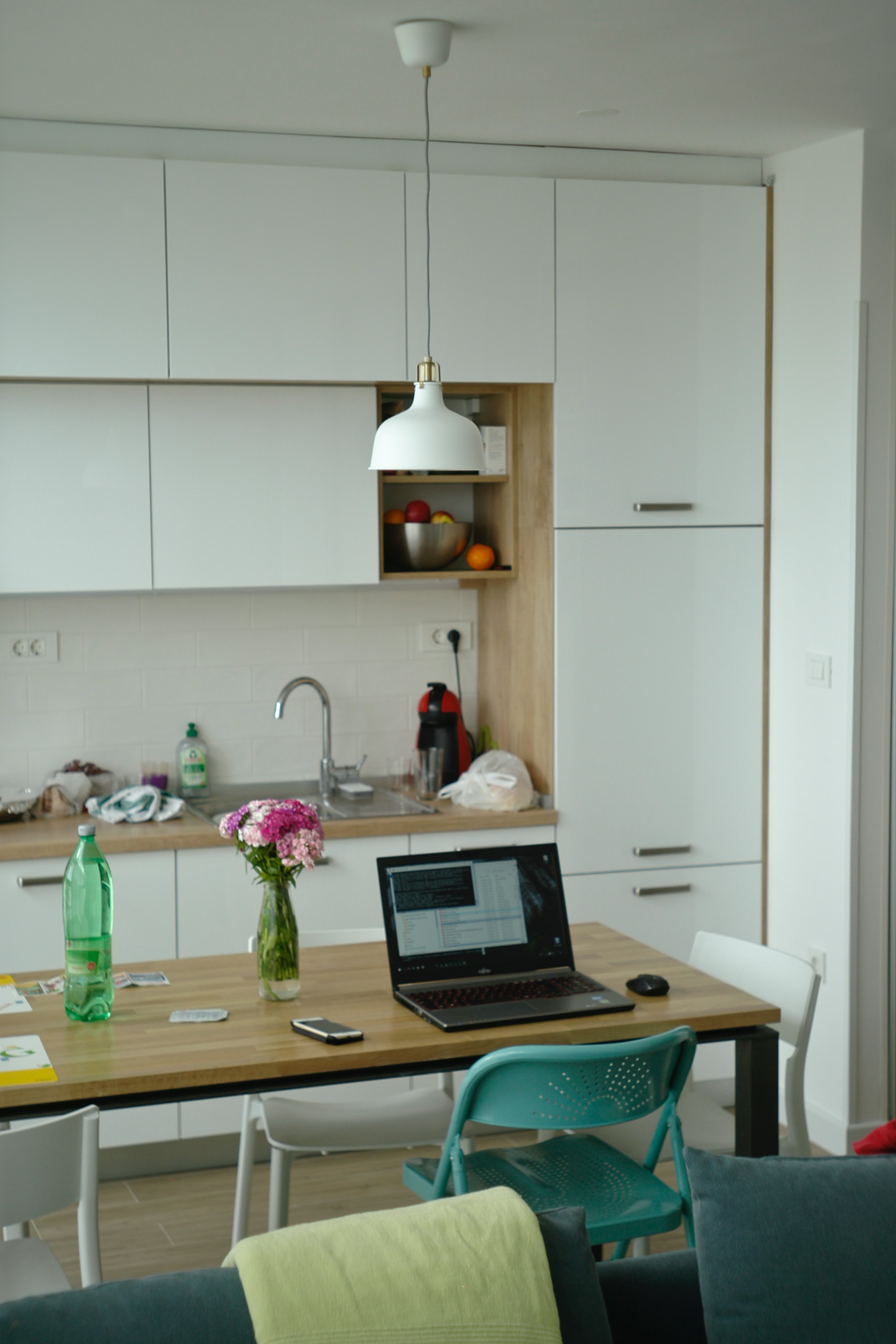 home office set up in kitchen with white cupboards
